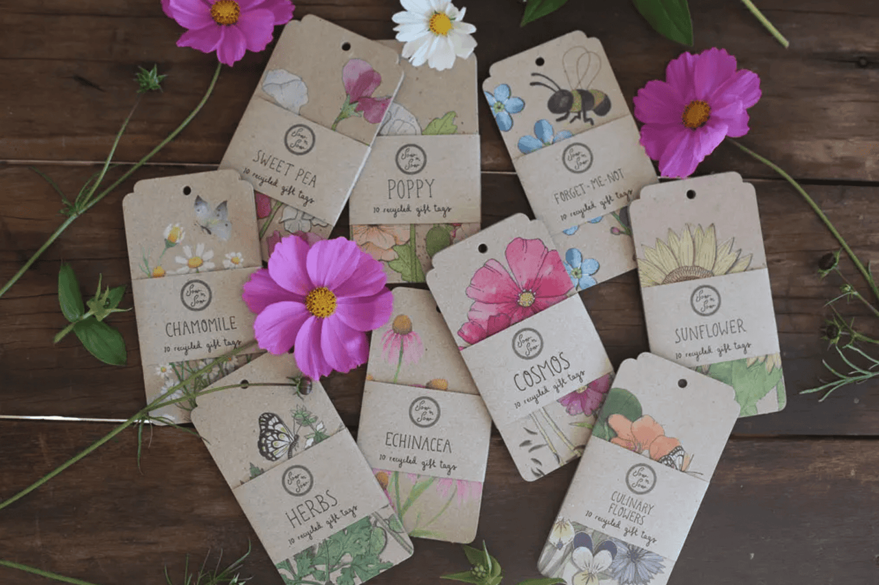 A bunch of Sow n Sow Sweet Pea flower tags on a wooden table.