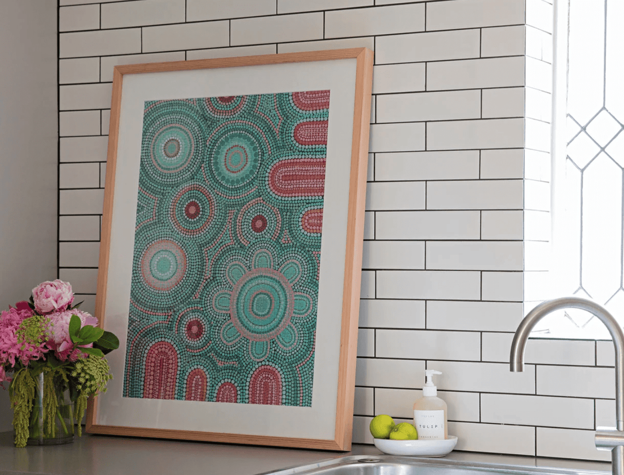 A kitchen with a 1000 Piece Puzzle - Giwaa-Yubaa print above a sink from Journey of Something.