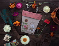Thumbnail for A bag of Seeds - Secret Garden from Sow n Sow, along with gardening tools, on a wooden table.