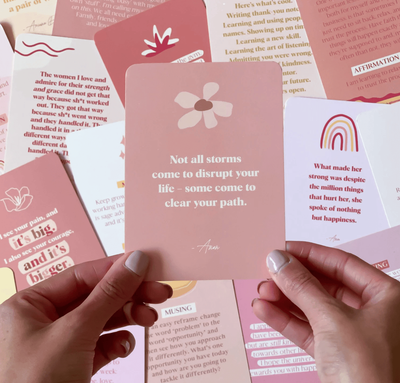 A hand holding up a pink card from the Collective Hub - Affirmations to Guide Your Journey - Box Card Set, with a quote on it.
