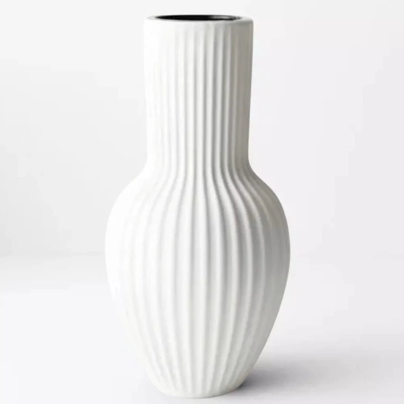 An Annix Tall Vase - White by Floral Interiors on a white surface.