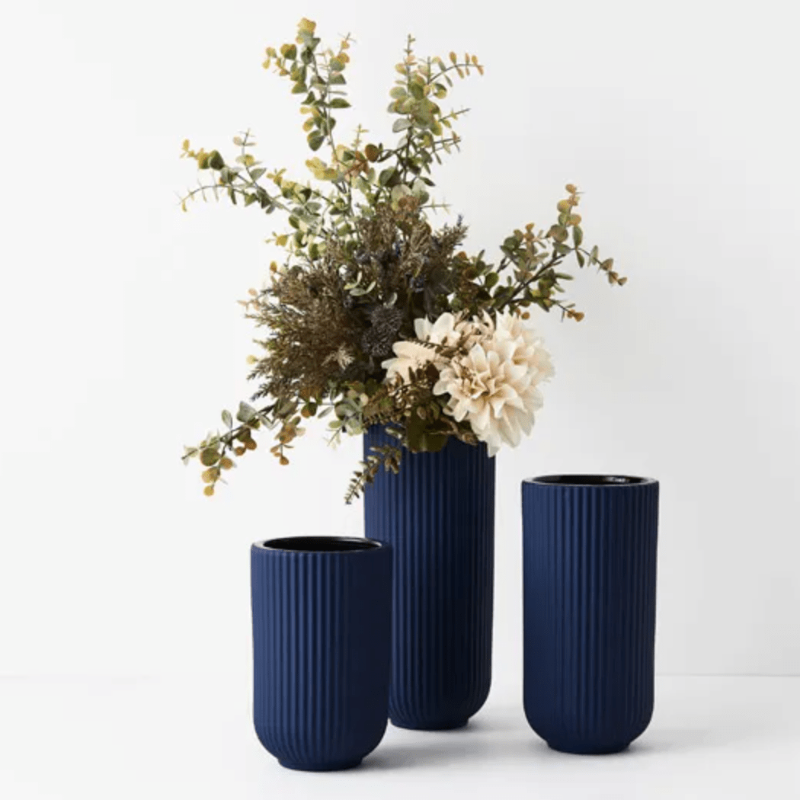 Three Floral Interiors Annix Vases - Cobalt with flowers in them.