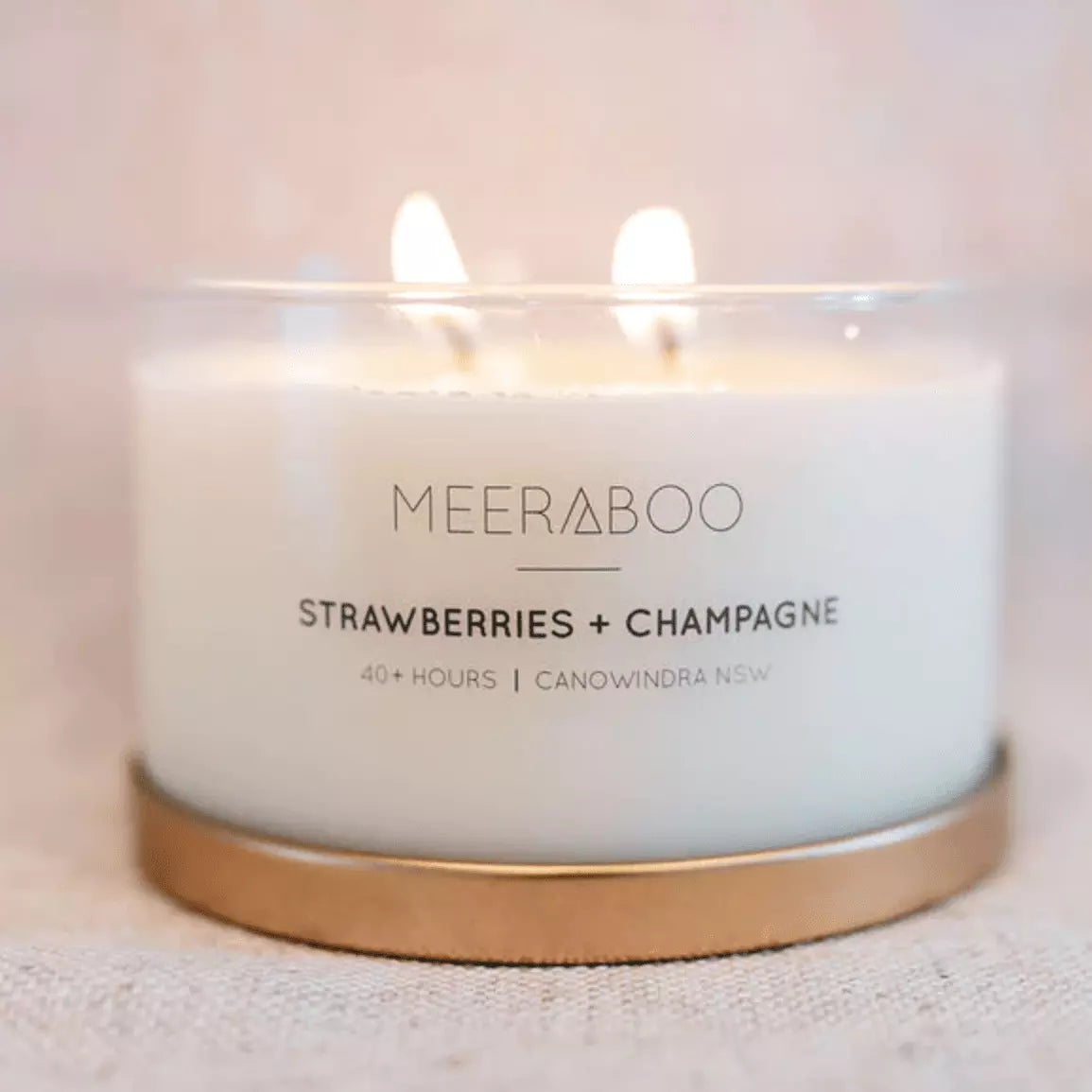 A Meeraboo Soy Candle - Strawberries and Champagne written on it.