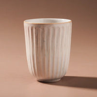 Thumbnail for The Juliette Latte Mug - White by Indigo Love features a vertical ribbed texture on brown, a hand-finished ceramic design with an off-white sheen, subtle tapering, and a reactive glaze effect.