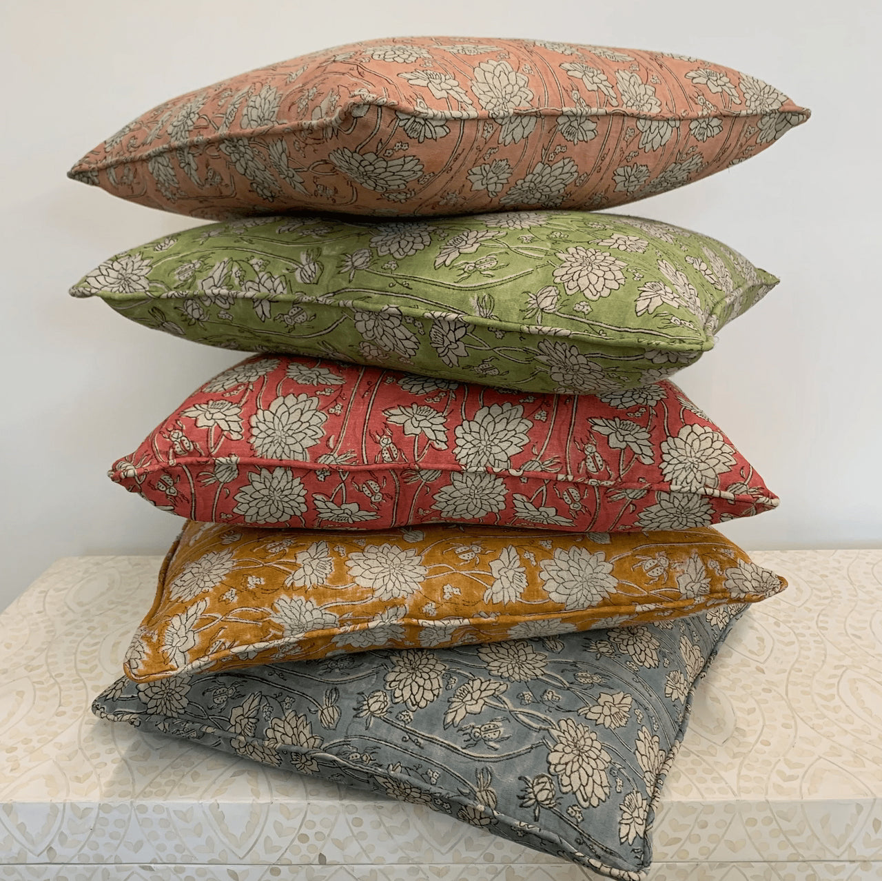 Four Linen Cushions - Classic Block Print - Pink by Ruby Traders stacked on top of each other.