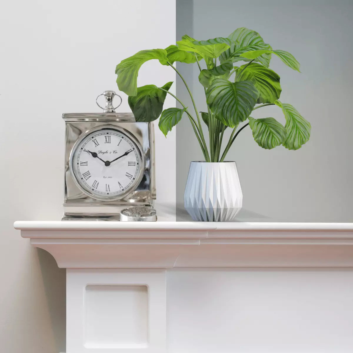 Silver Mantle clock sitting on Mantle piece with plant next to it