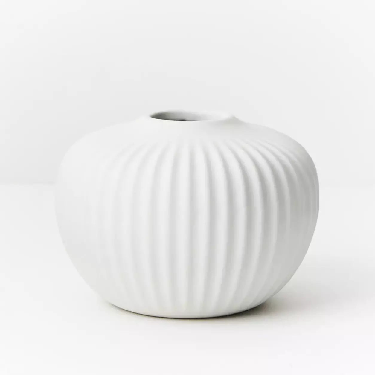 A Taza Vase - White by Floral Interiors on a white surface.