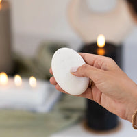 Thumbnail for A person holding a white Flameless Candle Luxury Remote in front of candles, adjusting the brightness with a remote control.