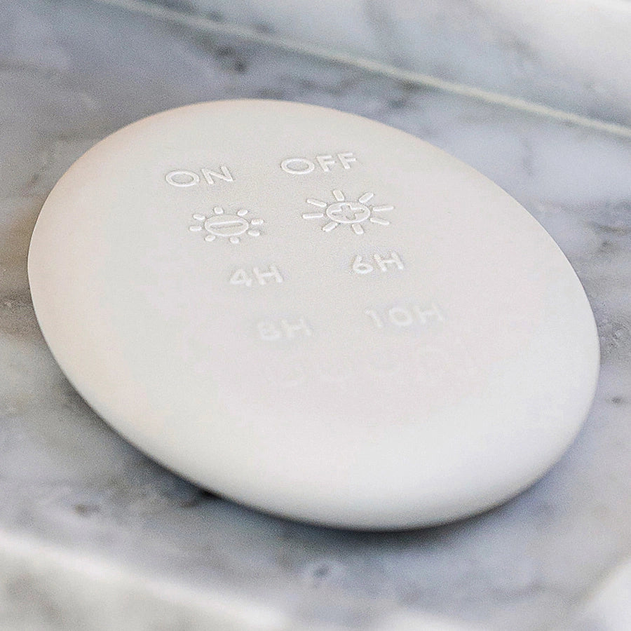 A white marble soap dish with a Enjoy Living Flameless Candle Luxury Remote on it.