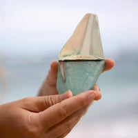 Thumbnail for A person holding a small Summer Salt Body Crystal Soap - AQUAMARINE - Lemongrass on the beach.