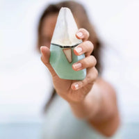 Thumbnail for A woman holding up a small bottle of water, surrounded by luxurious Summer Salt Body - Crystal Soap - AQUAMARINE - Lemongrass stone.