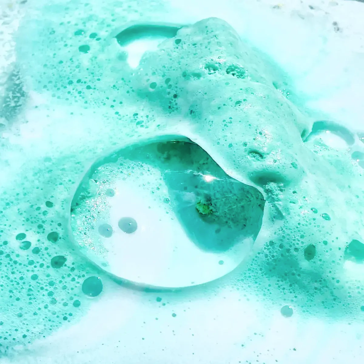 A close up of a Crystal Bath Bomb - Aquamarine - Lemongrass from Summer Salt Body, with bubbles in it, enhanced by the soothing effects of aromatherapy and essential oils.