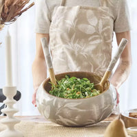 Thumbnail for A woman in an apron holding a Bindi Salad Bowl inspired by Australia's native flora, from the j.elliot brand.