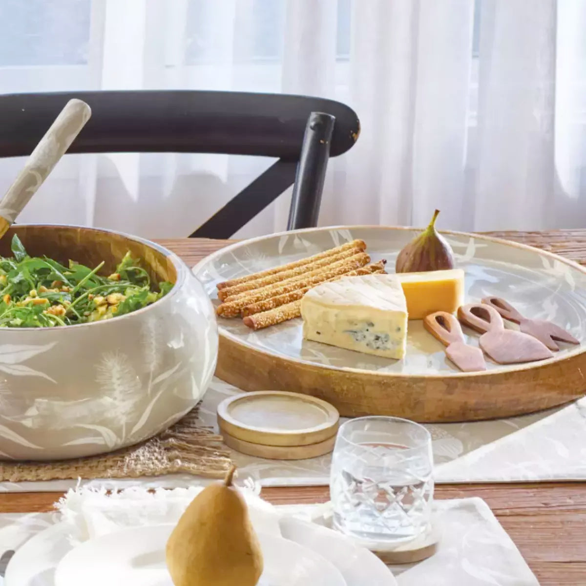 A table with plates of food and a Bindi salad bowl inspired by the j.elliot collection, showcasing the native flora of Australia.