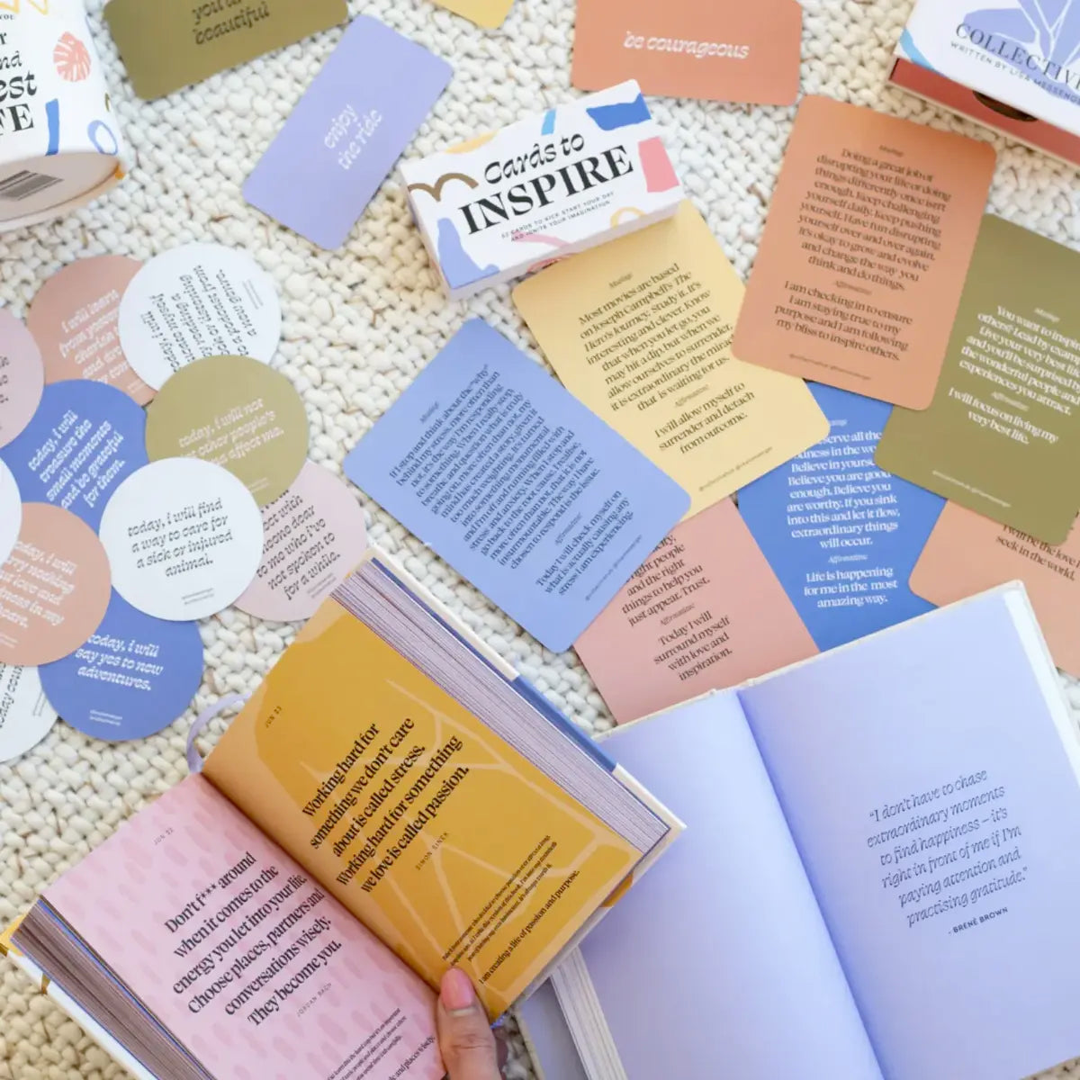 An open book with a lot of cards on it, filled with inspirational quotes and daily affirmations from "Daily Mantras to Ignite Your Purpose - V3" by Collective Hub.