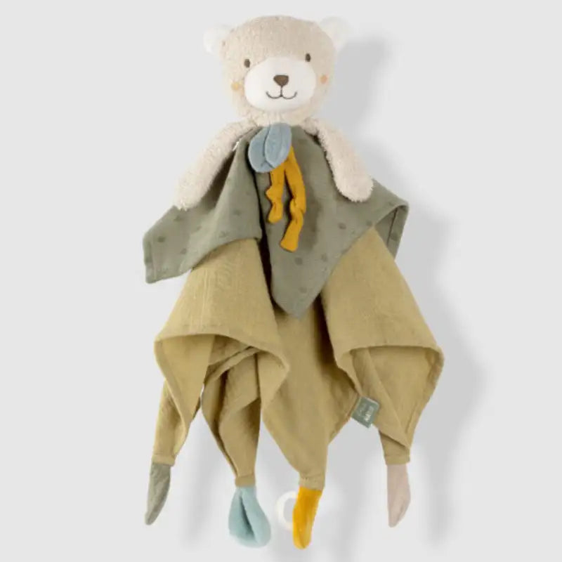 The Pilbeam FehnNATUR Comforter Bear is a soft security blanket with a smiling bear head, made of green and beige organic cotton, and features colorful knotted corners for sensory development.