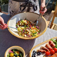 Thumbnail for A woman is preparing a salad in a j.elliot Como Salad Bowl.