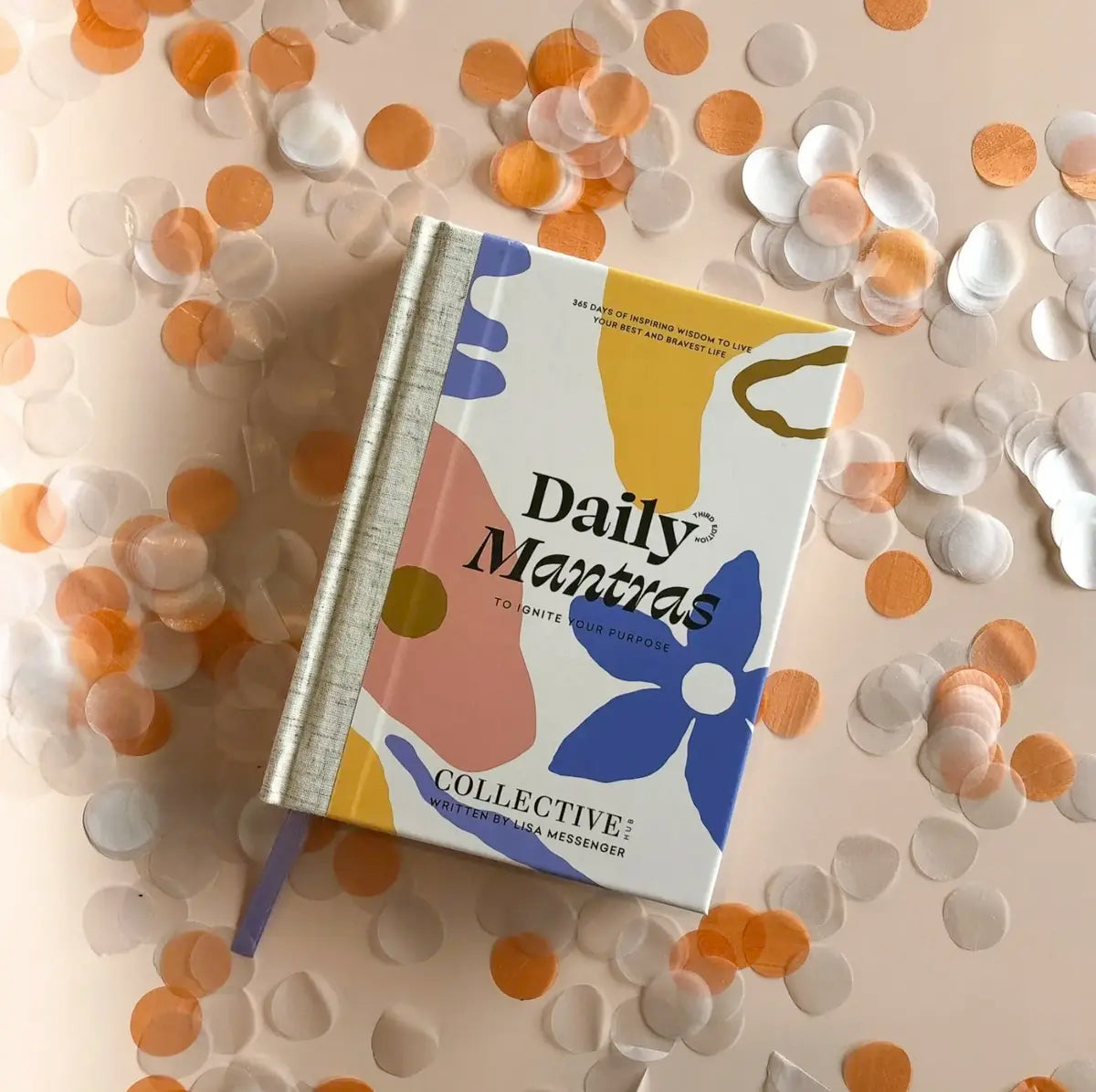 A curated book titled "Daily Mantras to Ignite Your Purpose - V3" by Collective Hub, filled with inspirational quotes, surrounded by confetti.