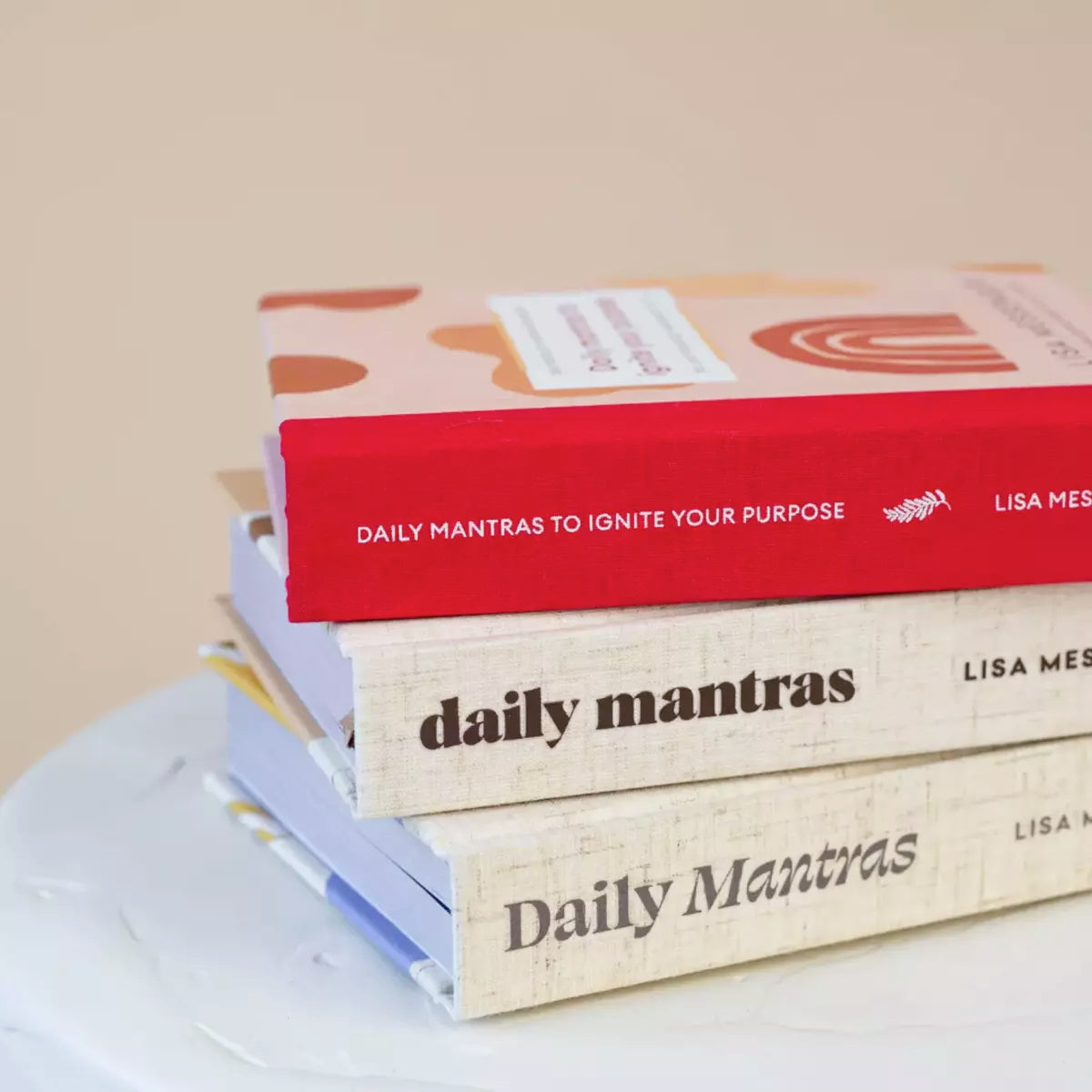 Three books, including one best seller and the second edition of Daily Mantras to Ignite Your Purpose, stacked on top of each other.