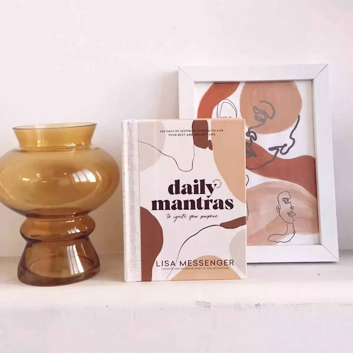Collective Hub's "Daily Mantras to Ignite Your Purpose Second Edition" book on a table.