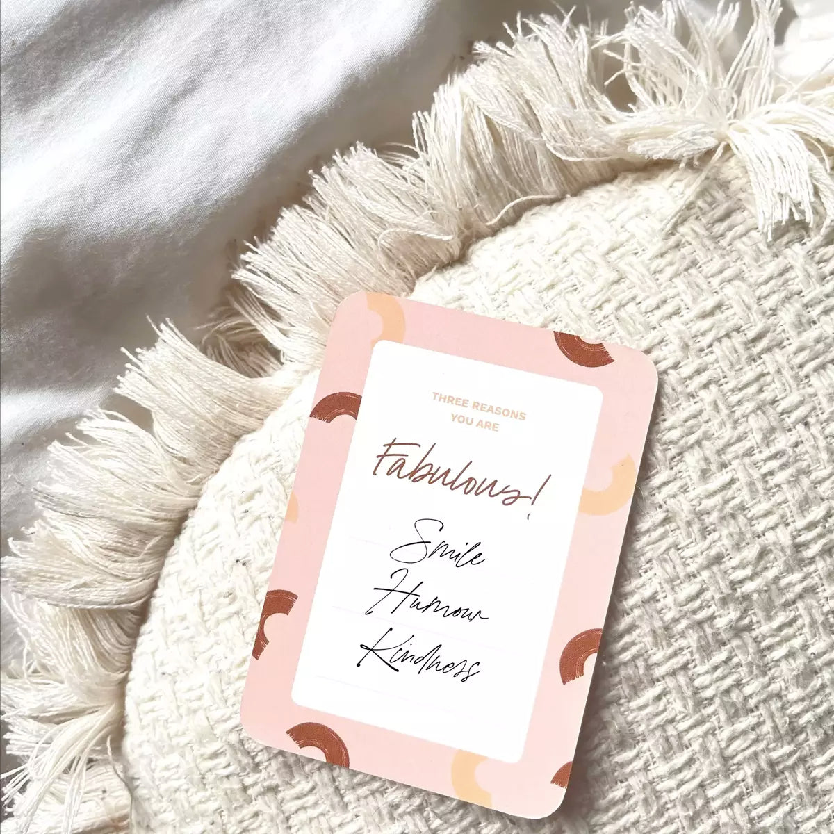 A Collective Hub Kindness Card with the word 'February' on top of a pillow.