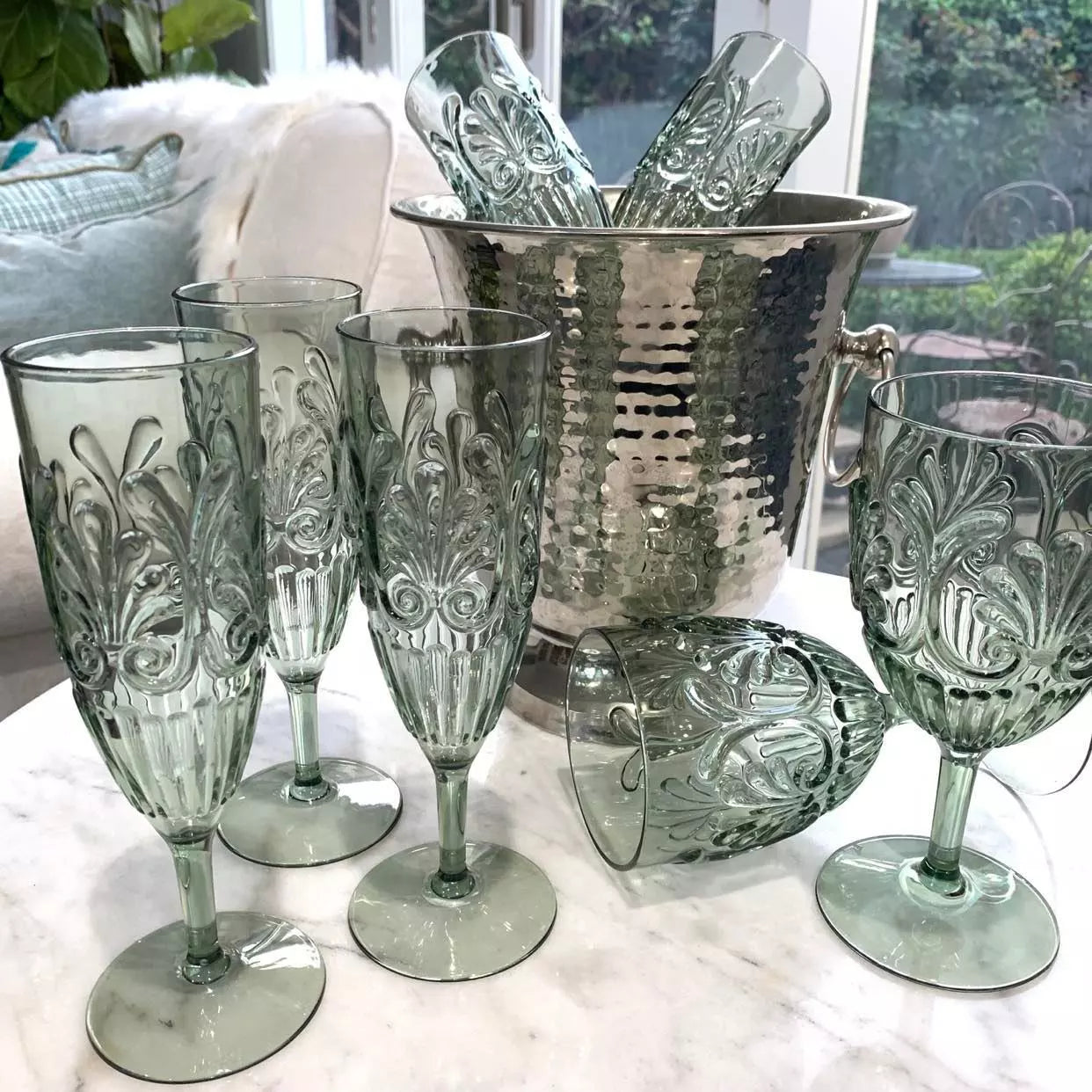 A set of Flemington Acrylic Champagne Flute - Sage Green wine glasses by Indigo Love on a table.
