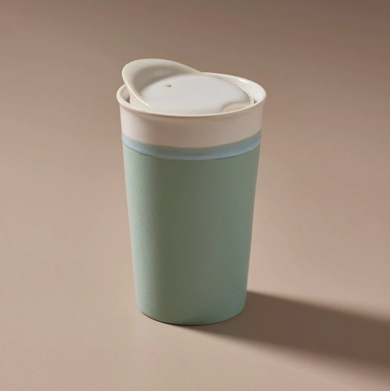 An Indigo Love Keeper Cup - Ceramic - Marine travel mug with a sealable lid sitting on a table.