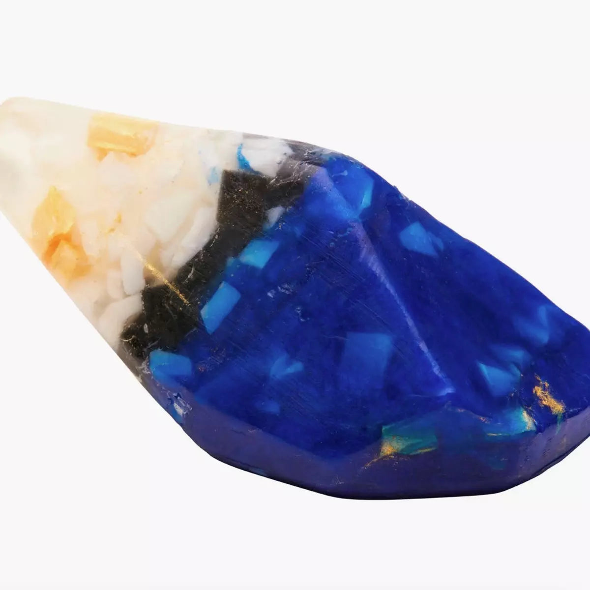 A Crystal Soap - LAPIS LAZULI - Jasmine, Frankincense + Lime from Summer Salt Body, known for its high vibrational energy, adorned in shades of blue and white. A coating of sand accentuates its natural beauty.