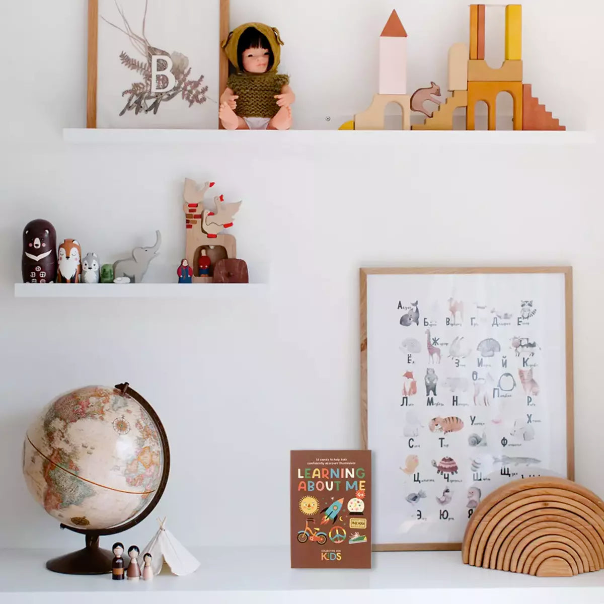 A child's room with Learning About Me wooden shelves and a globe, designed to inspire kids' self-love and confidence by Collective Hub.
