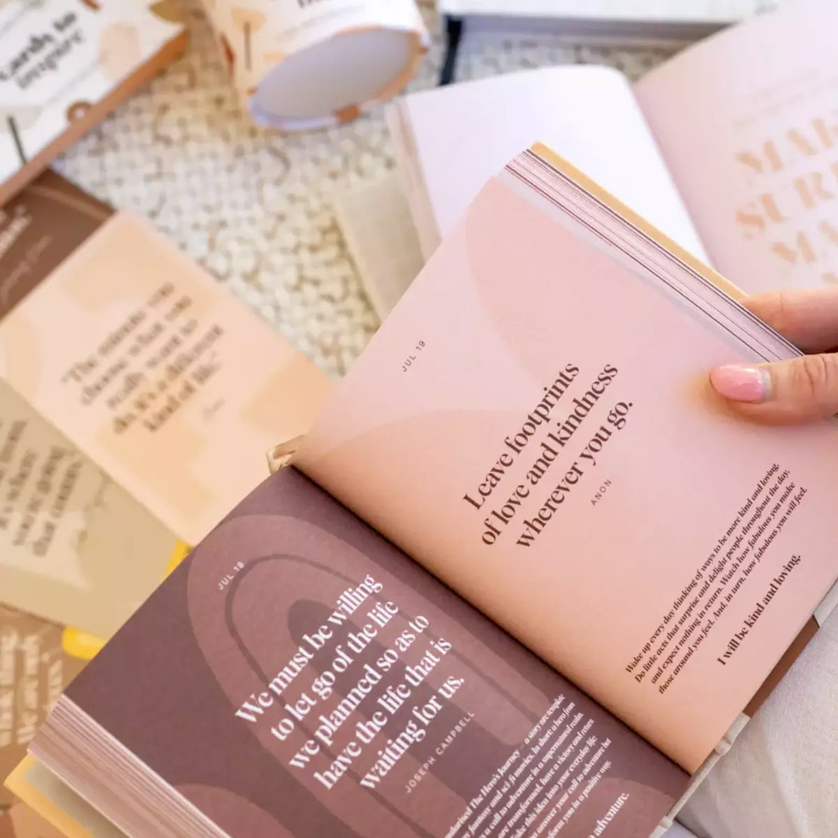 A person holding the Daily Mantras to Ignite Your Purpose Second Edition book by Collective Hub with an inspiring quote on it.