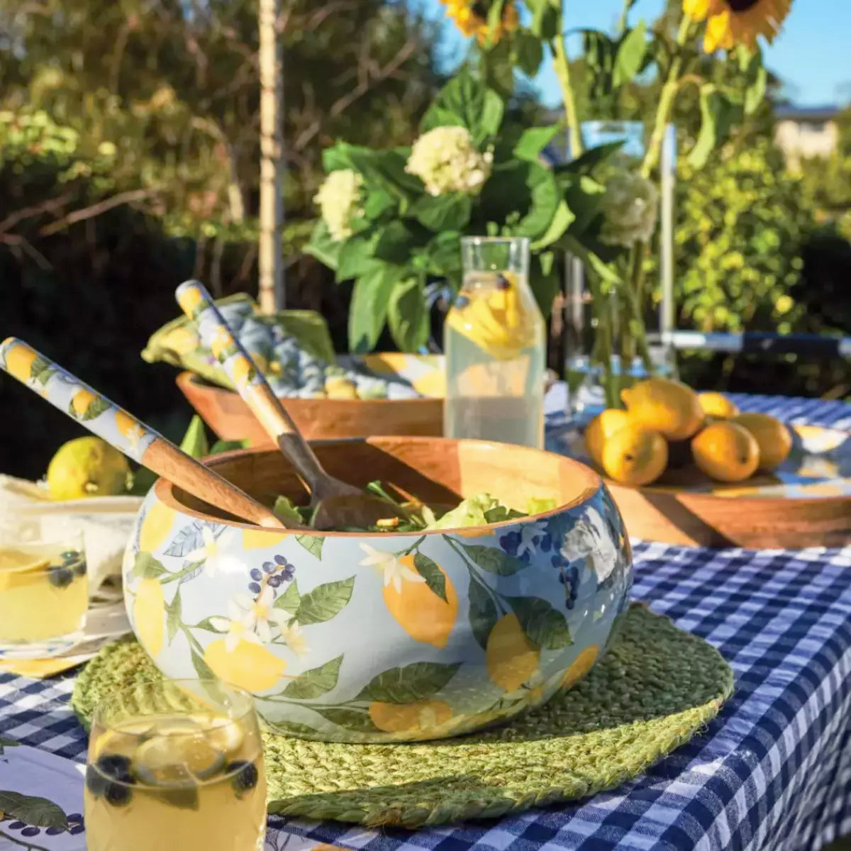 A table setting with Lemon Salad Servers by j.elliot on a mango wood tablecloth.