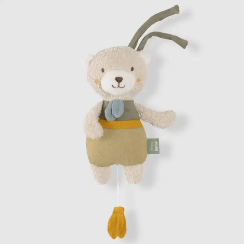 The FehnNATUR Mini Musical Bear by Pilbeam features soft beige fur, a green and mustard outfit, a blue scarf, and two fabric loops on its head. A yellow pull cord hangs below. Ideal as a sleeping aid. Presented against a plain white background.