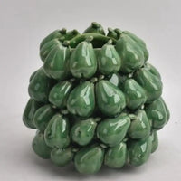 Thumbnail for The Mode Pear Vase by Mediterranean Markets is a green ceramic vase inspired by Sicilian design, with glossy pear shapes covering its rounded surface, set against a plain light gray background.