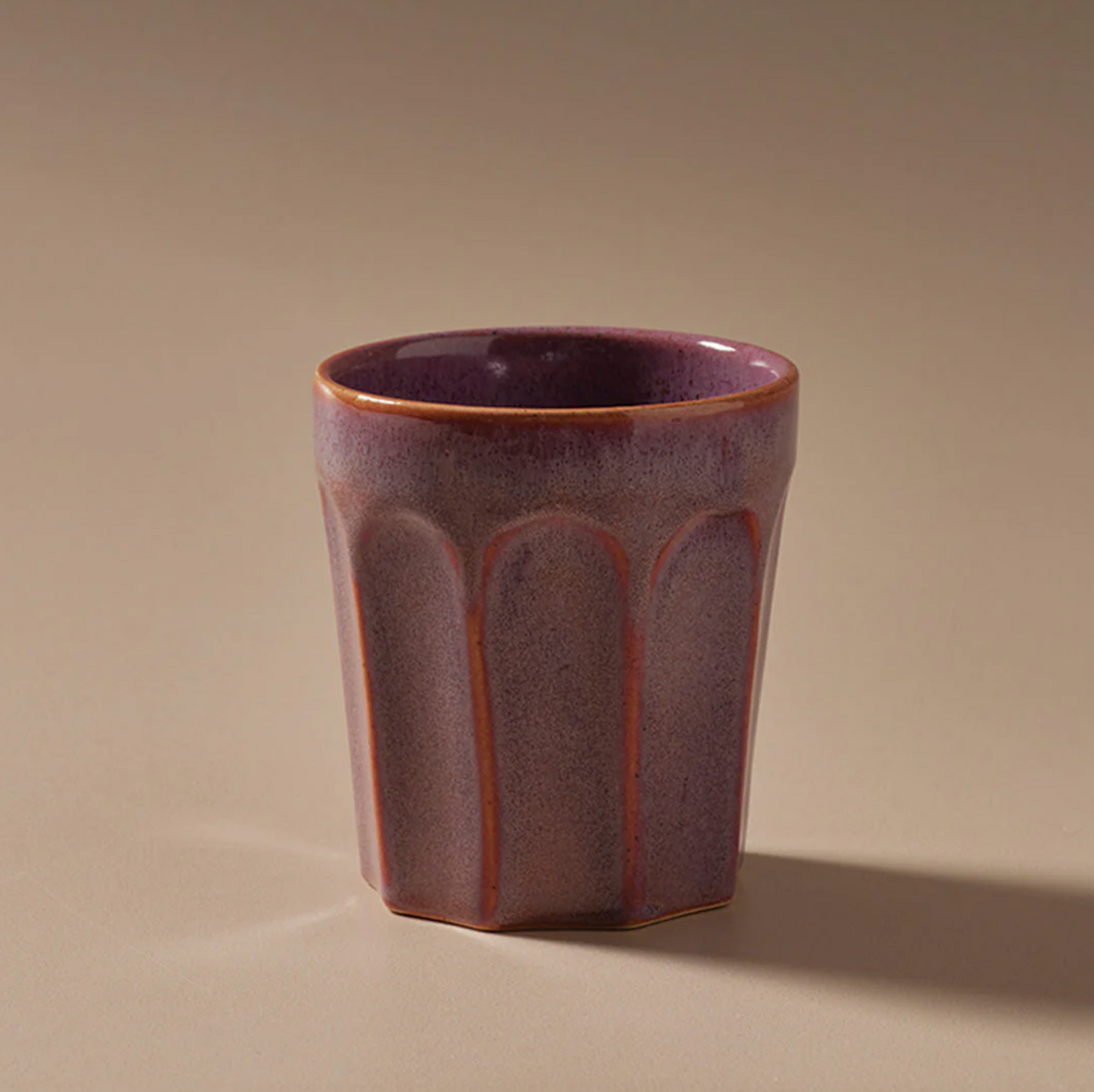 A small Indigo Love Ritual Latte Cup sitting on a beige surface.