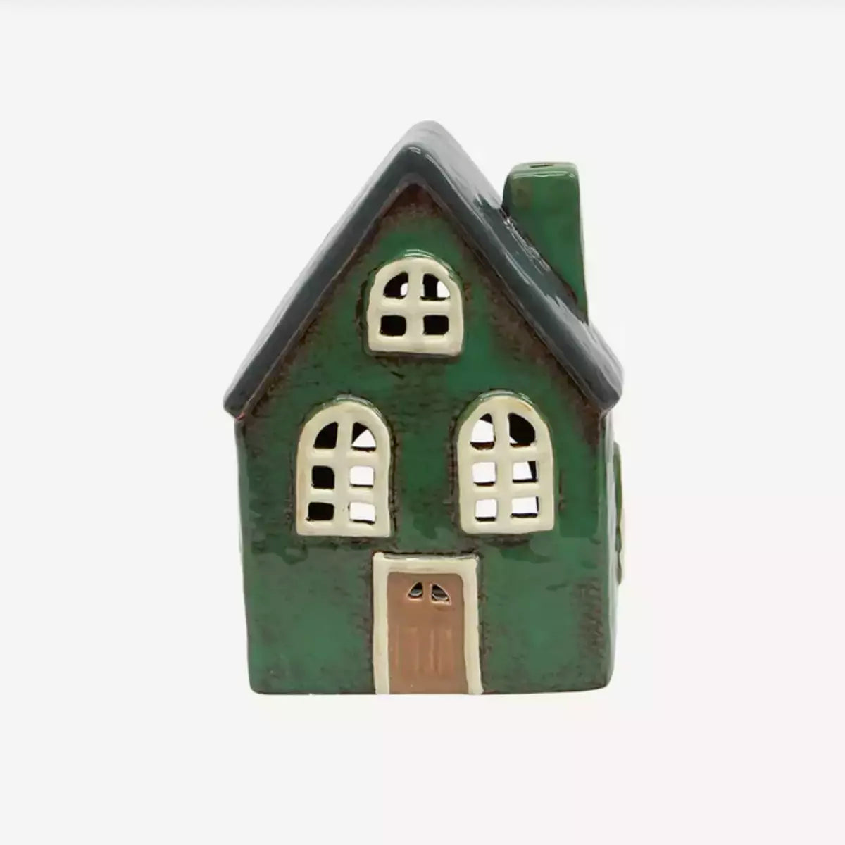 A small French Country Collections Christmas Village Barn - Green on a white background, decorated with tea lights for a cozy and festive Christmas village.