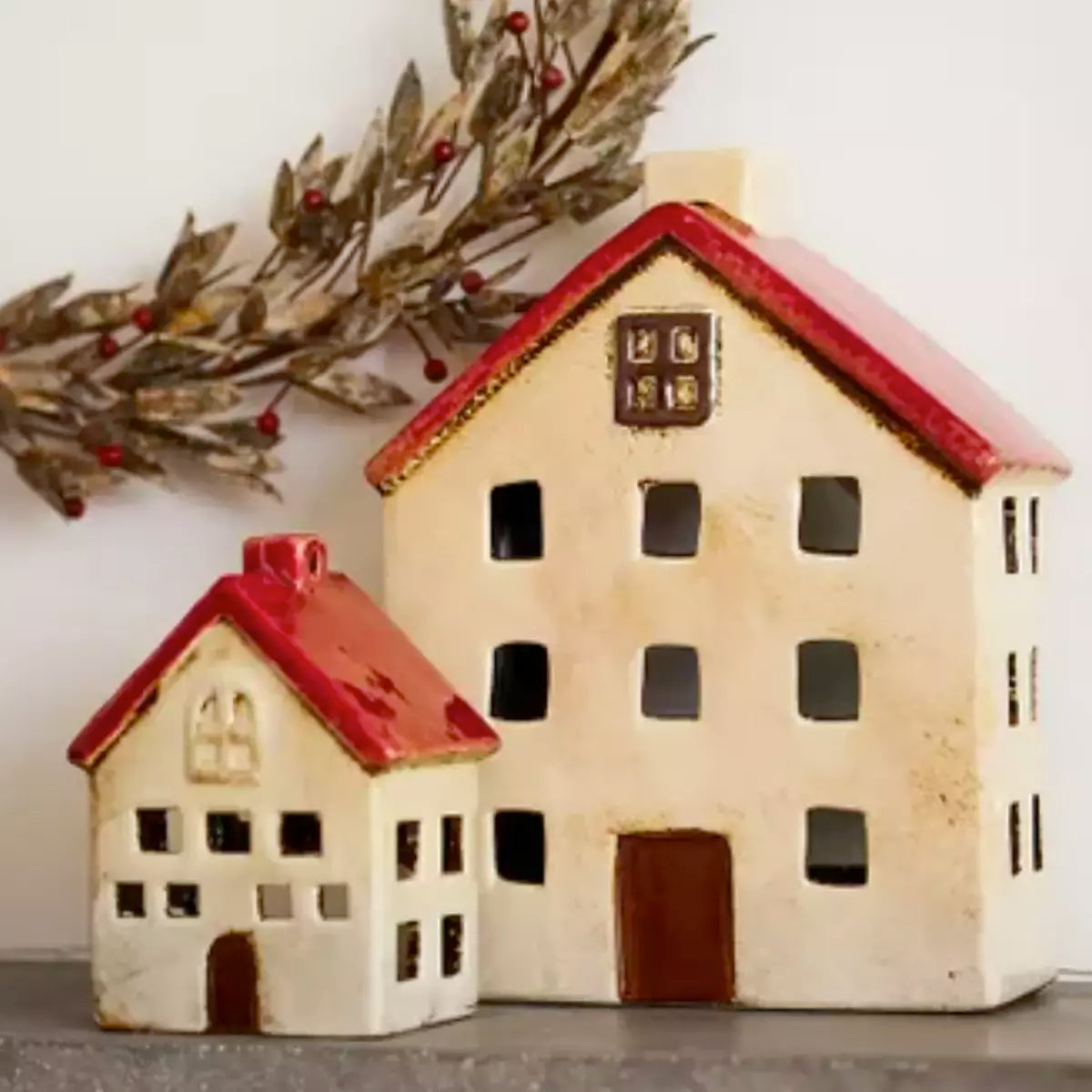 Two French Country Collections Christmas Village Villa ceramic house figurines on a mantle.